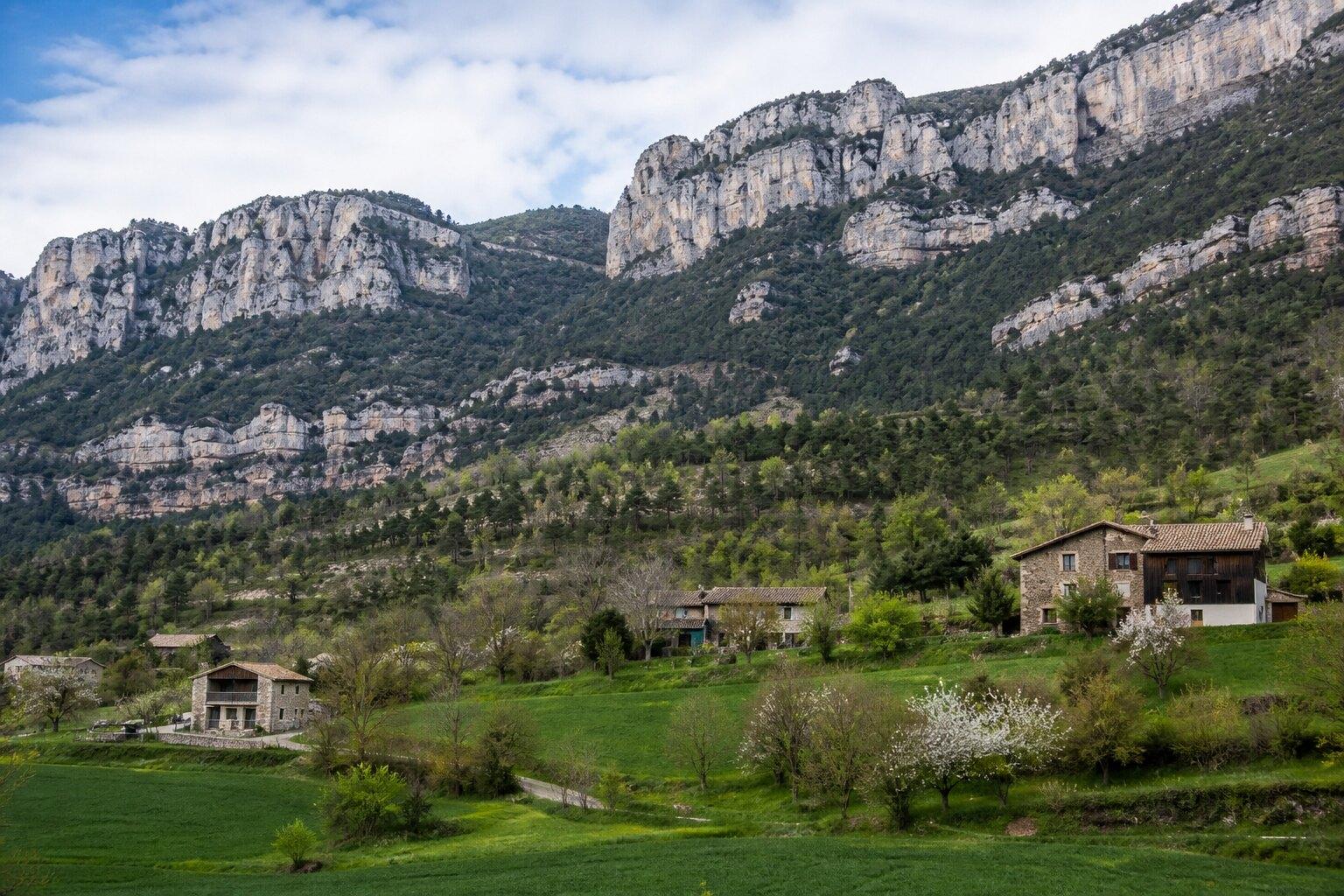 Scattered farmhouses beneath limestone ridges in Odèn, Solsonès